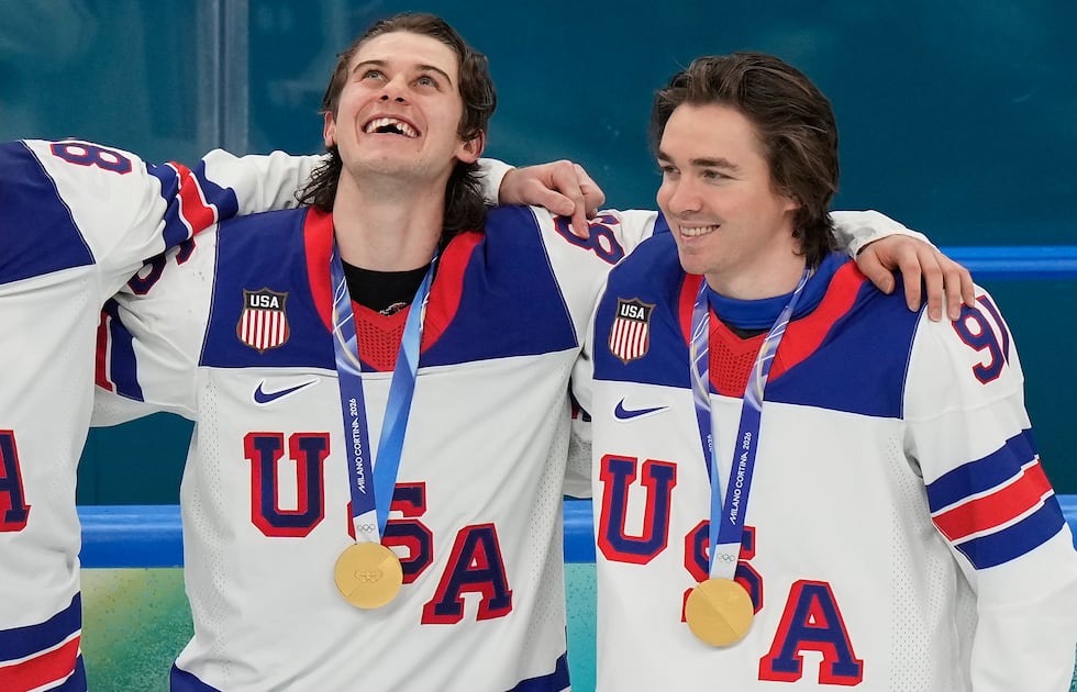 United States' Jack Hughes (86) and Clayton Keller (91) react after receiving their gold...